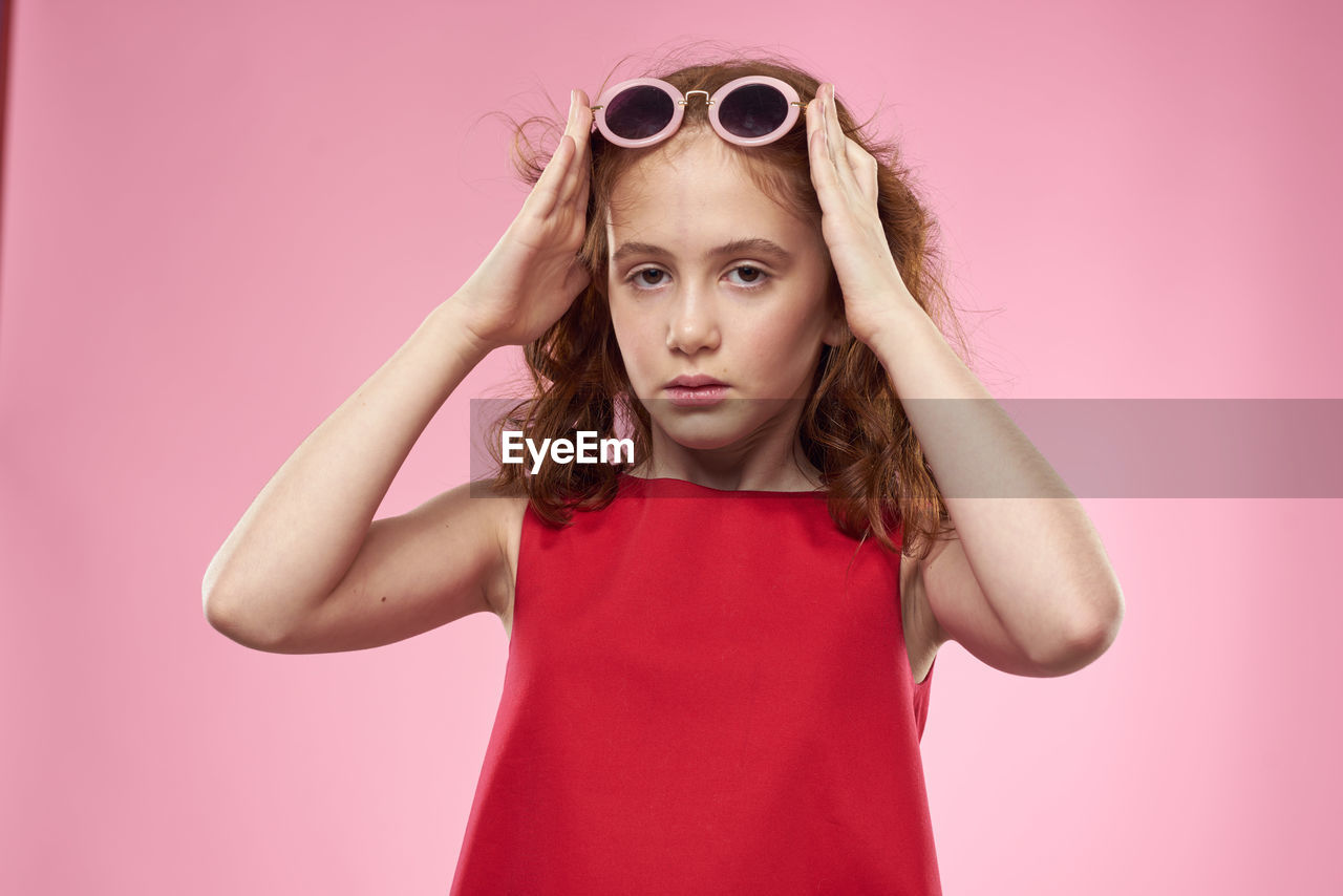 pink, child, portrait, childhood, one person, fashion, studio shot, looking at camera, red, glasses, indoors, colored background, women, photo shoot, sunglasses, front view, purple, female, hairstyle, clothing, vision care, magenta, waist up, emotion, pink background, eyewear, blond hair, facial expression, dress, goggles, cute, human face, long hair, standing, looking, person, serious
