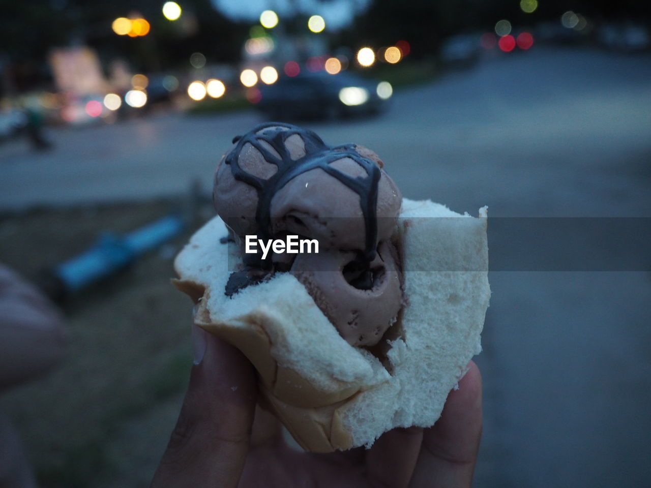 Close-up of hand holding ice cream at night