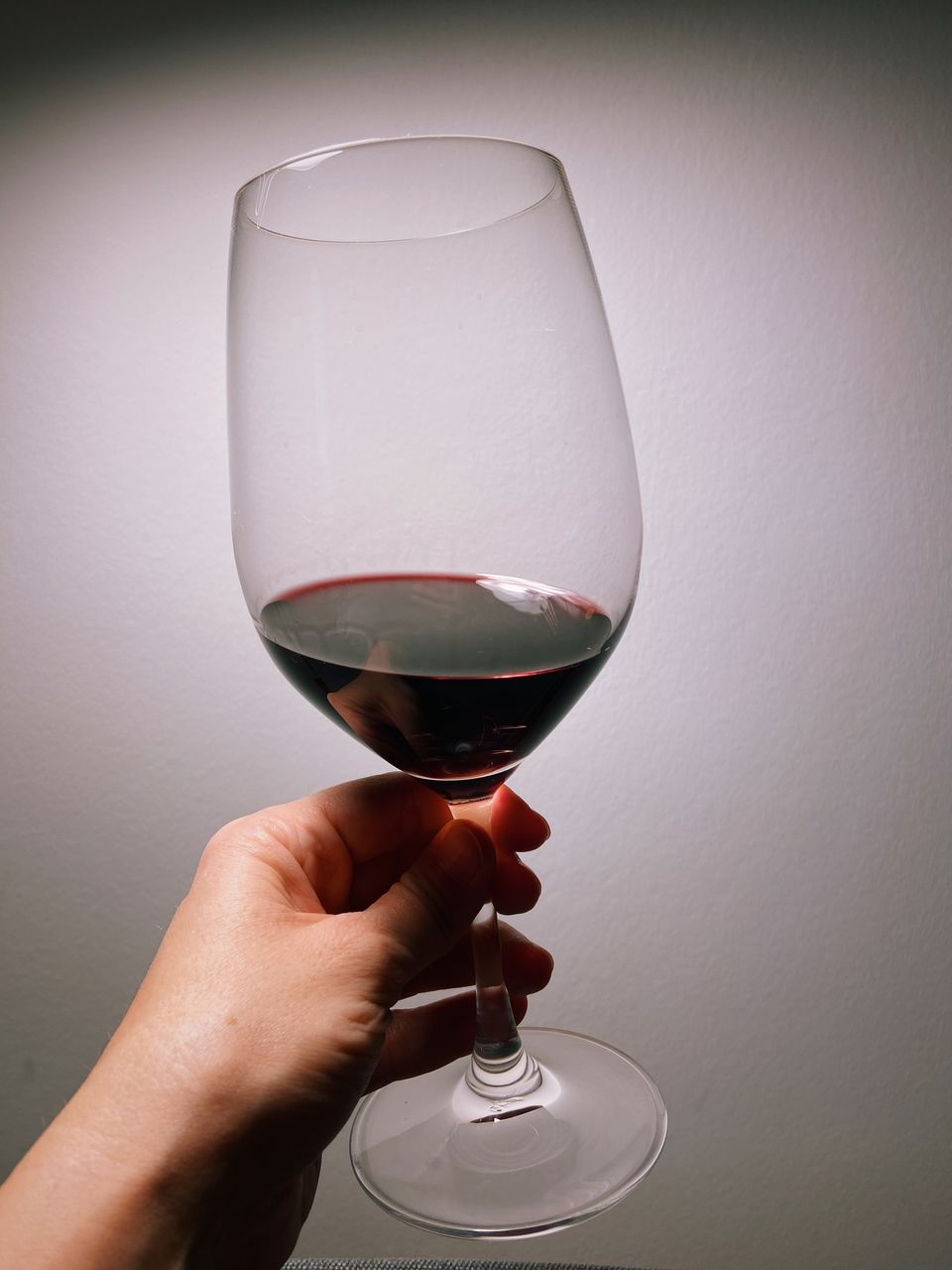 CLOSE-UP OF HAND HOLDING GLASS OF WINE