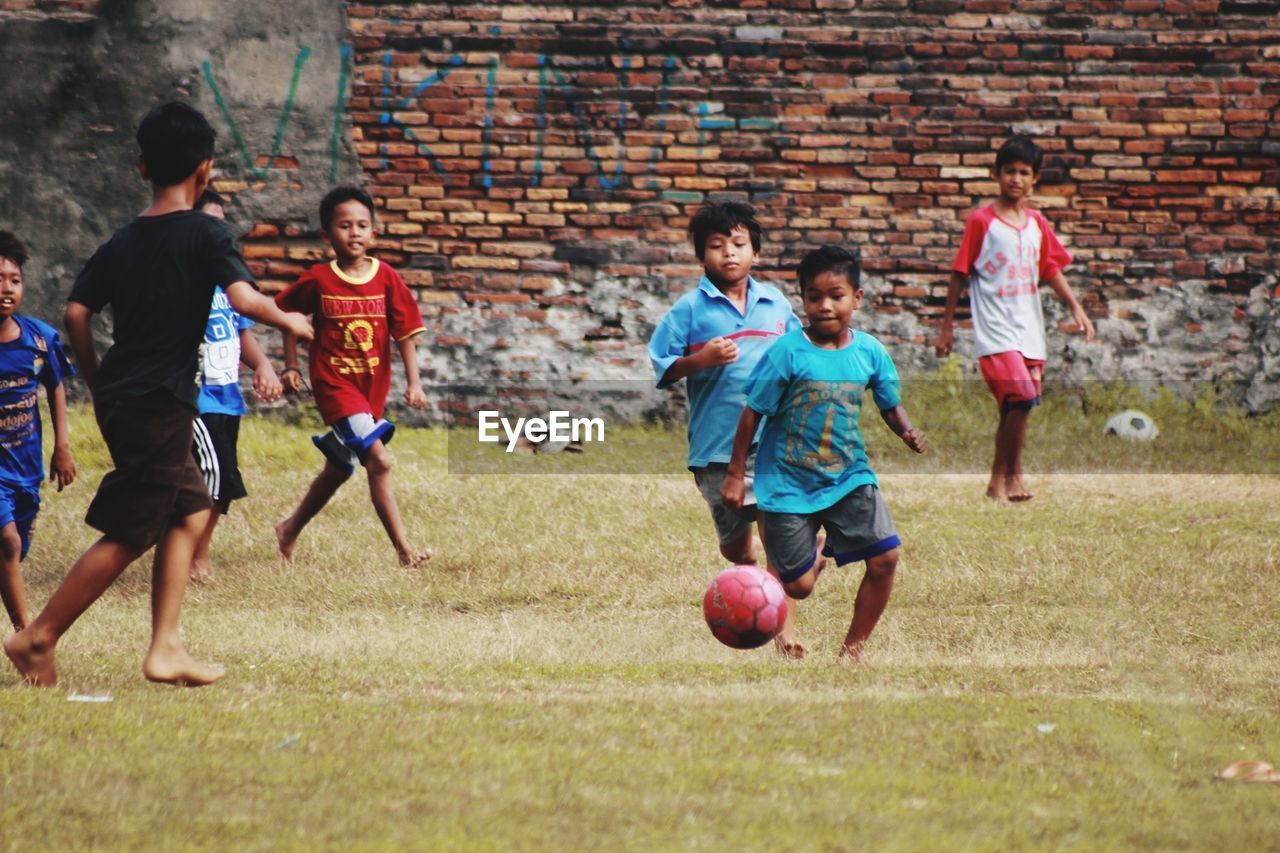PEOPLE PLAYING SOCCER BALL ON FIELD