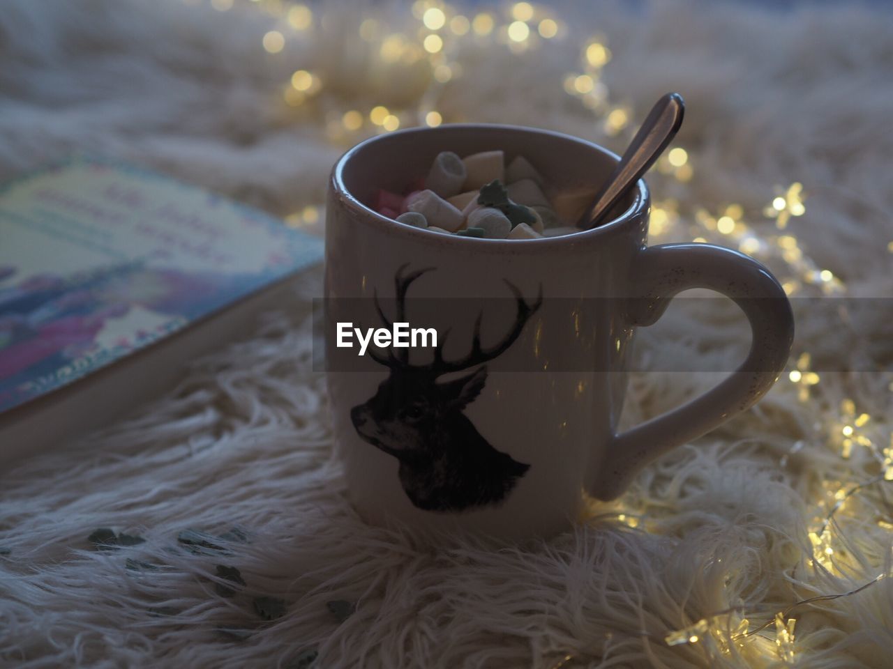 Close-up of hot chocolate in cup on bed during christmas