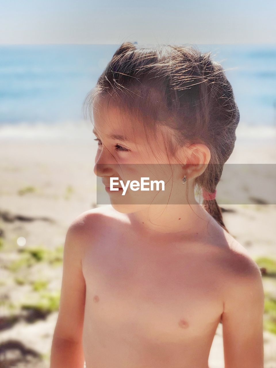 Midsection of shirtless girl at beach - ID: 164137122