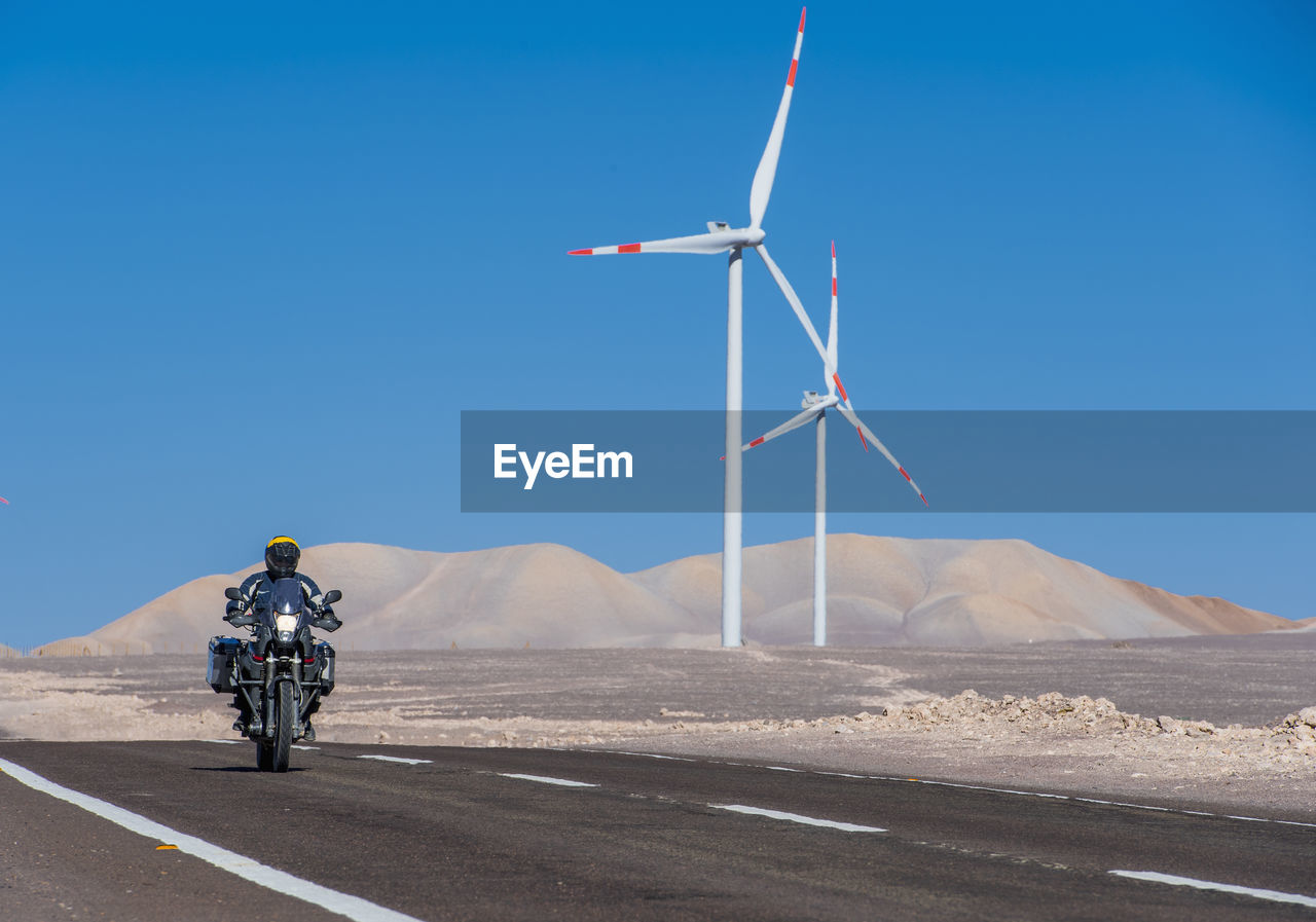 Man riding his adv motorbike at wind farm in the remote atacama desert