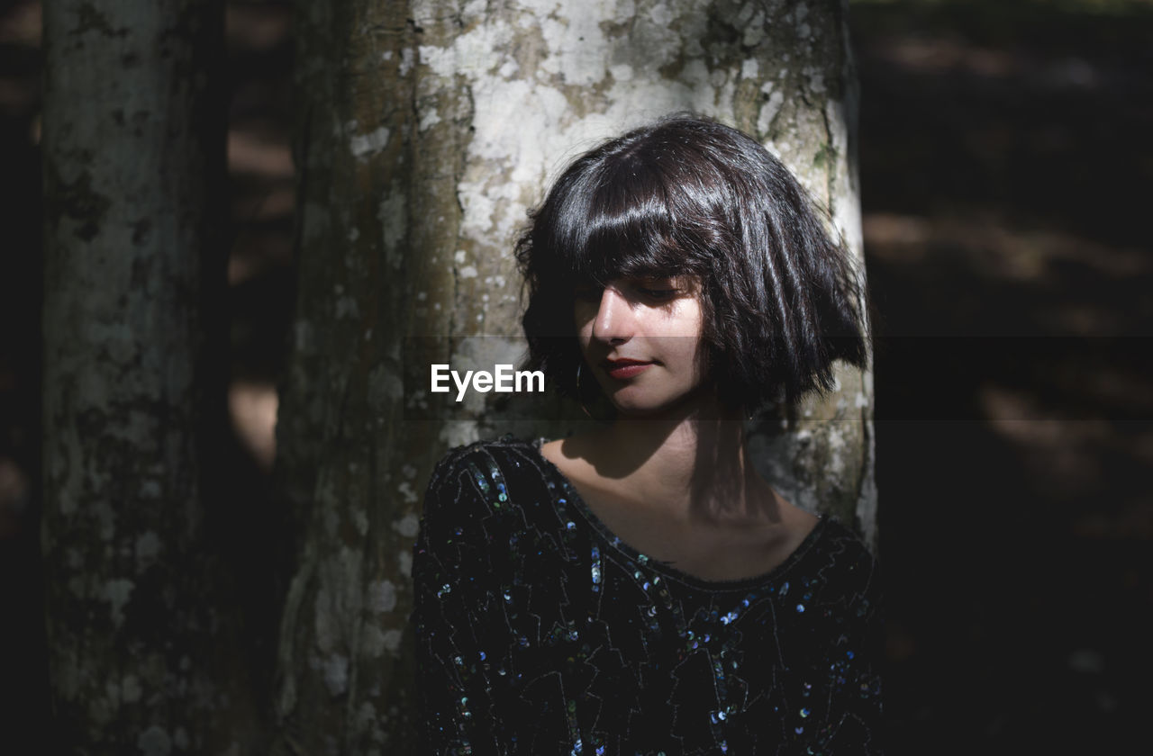 Young Woman With Short Hair Standing By Tree Trunk On Eyeem