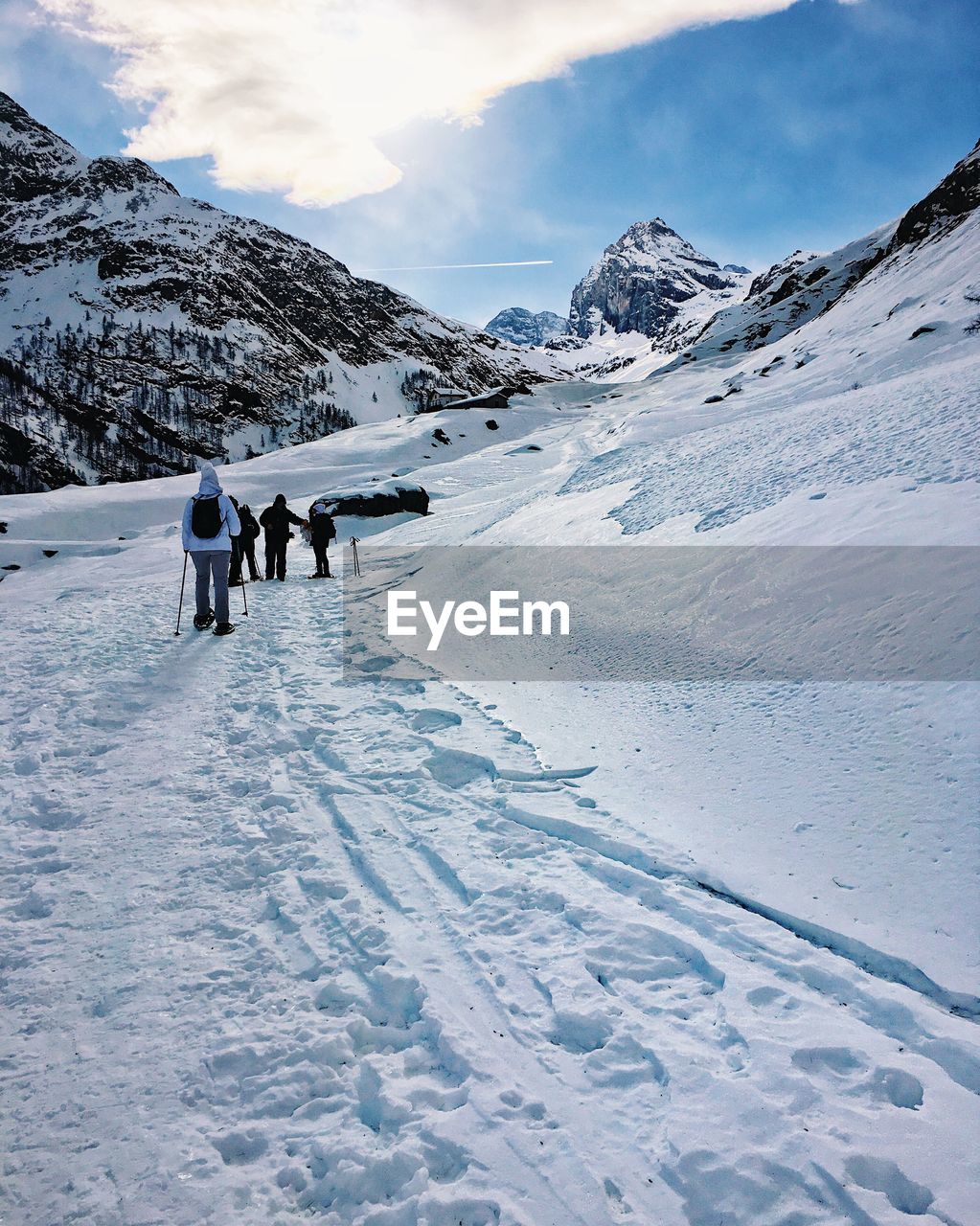 PEOPLE ON SNOWCAPPED MOUNTAINS AGAINST SKY