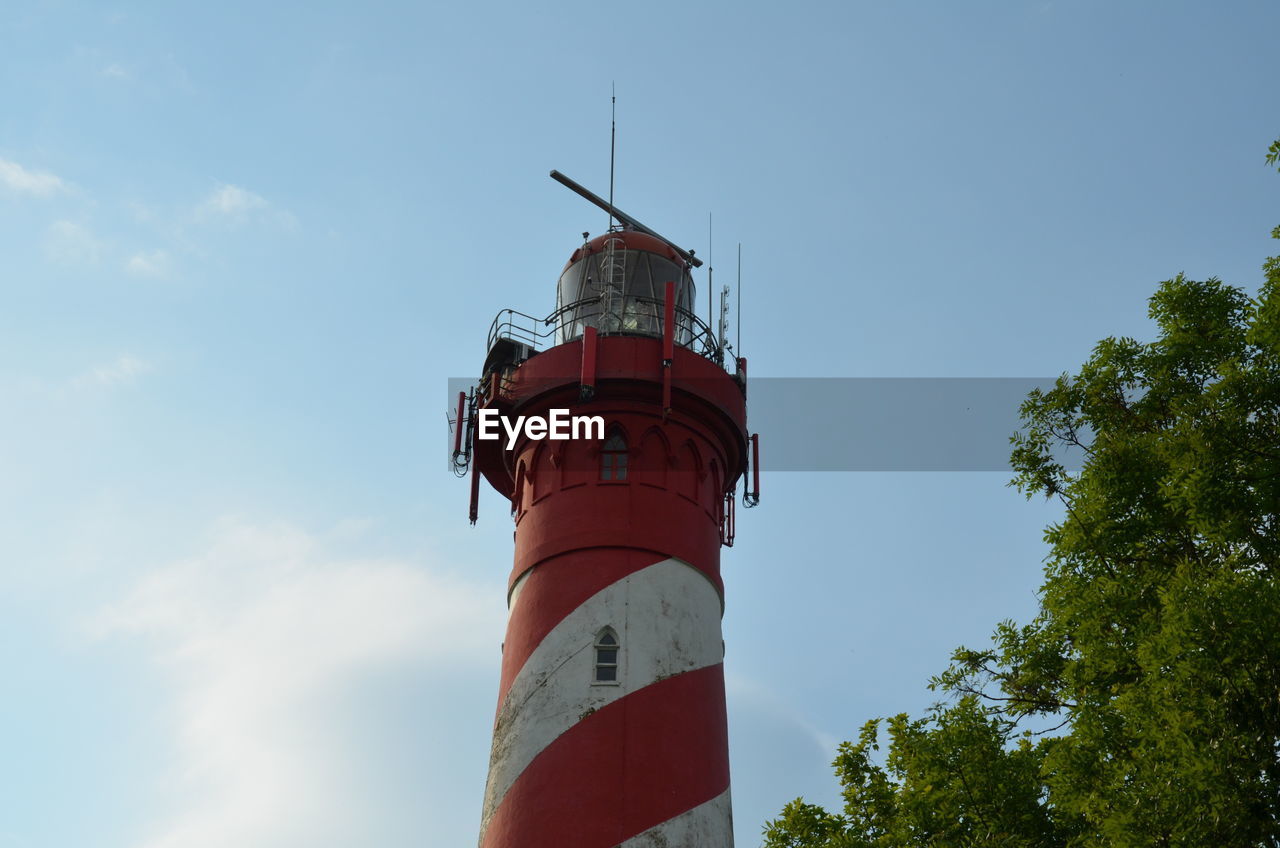 LOW ANGLE VIEW OF LIGHTHOUSE AGAINST BUILDING AND SKY