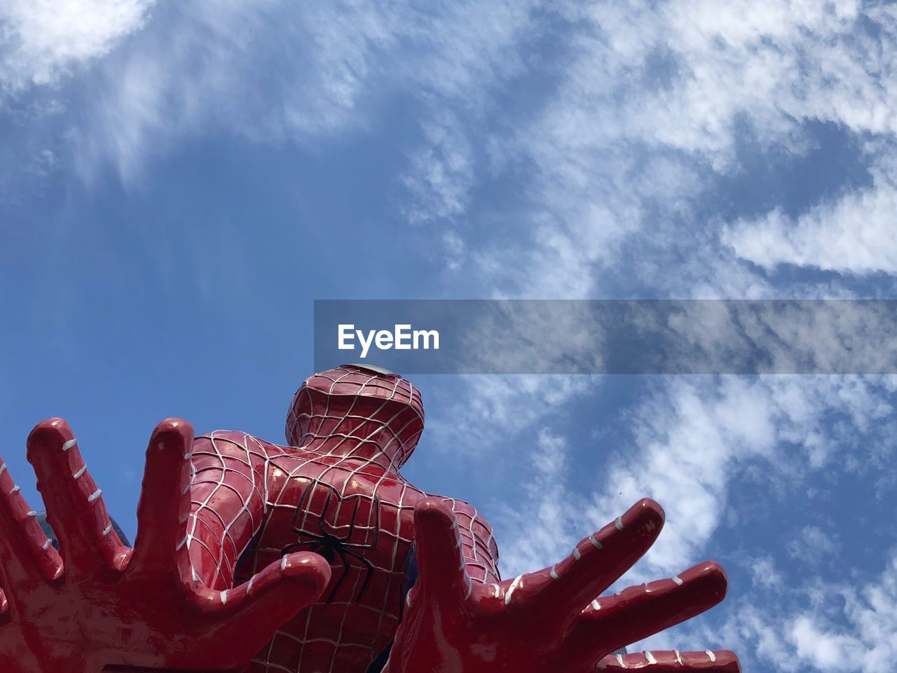 LOW ANGLE VIEW OF RED HAND AGAINST SKY