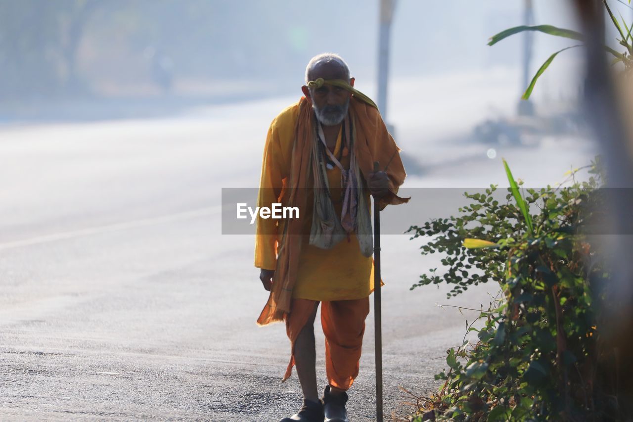 Portrait of monk standing on road in city
