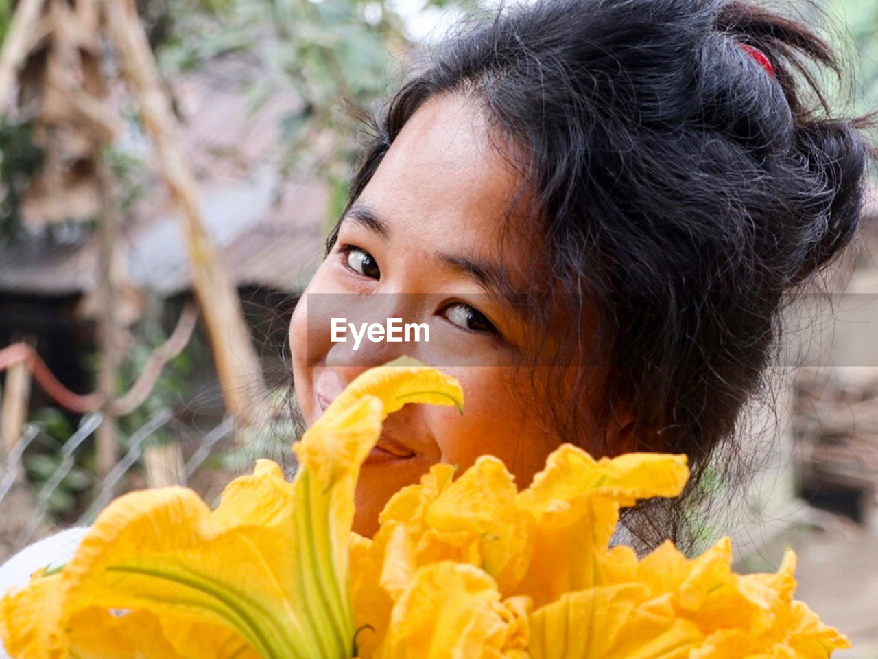 Close-up portrait of woman holding yellow flower