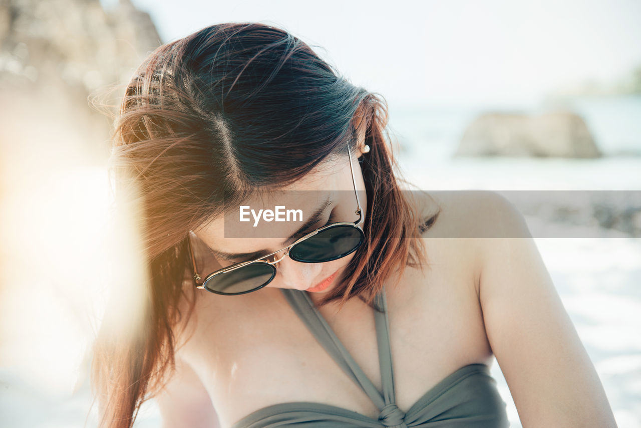 Close-up of woman wearing sunglasses at beach