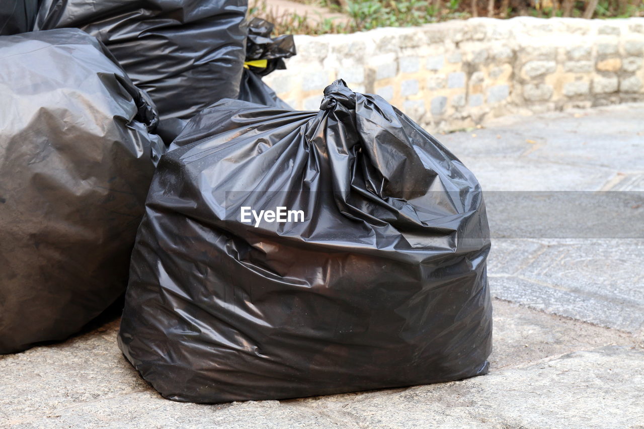 Close-up of garbage bags on road