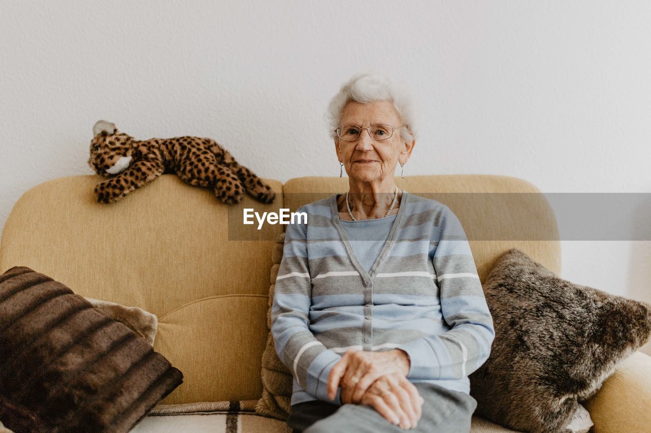 Portrait of senior woman sitting on sofa at home