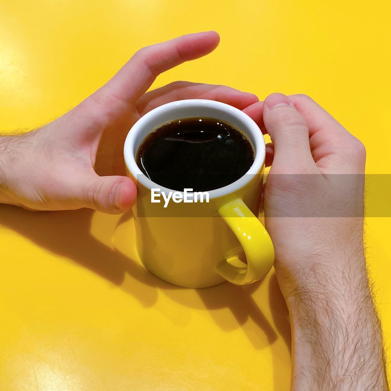 MIDSECTION OF MAN HOLDING COFFEE