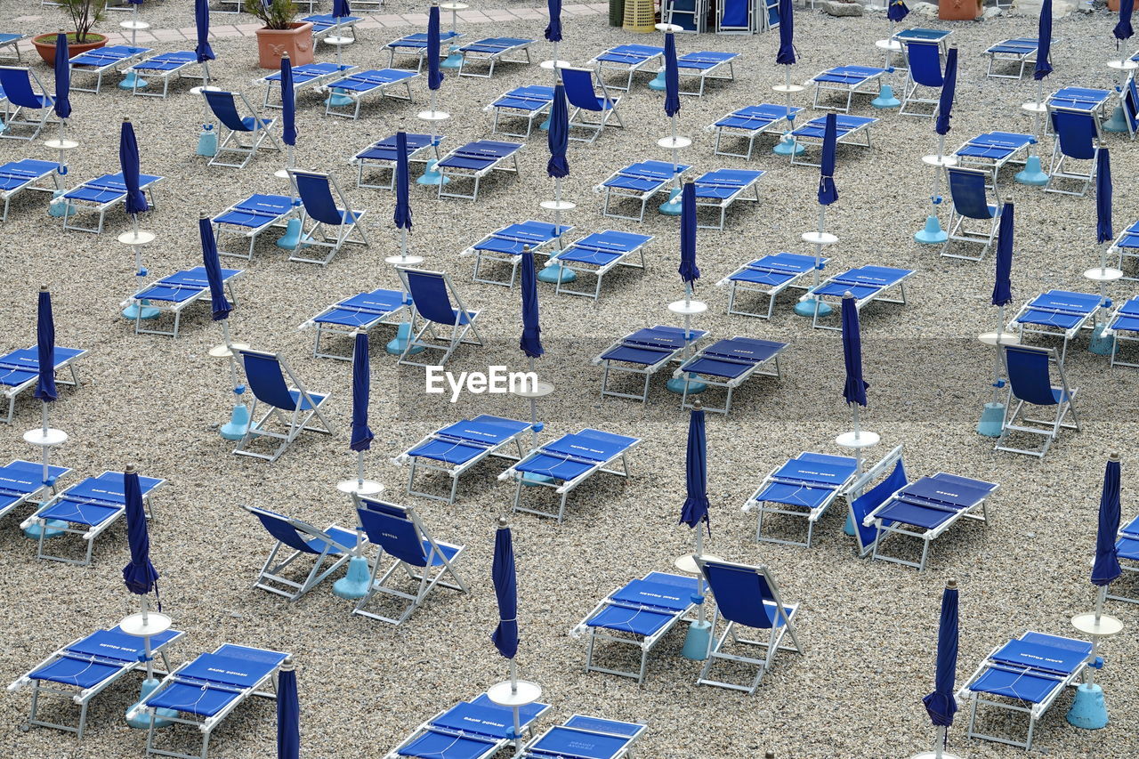 HIGH ANGLE VIEW OF CHAIRS ON SAND