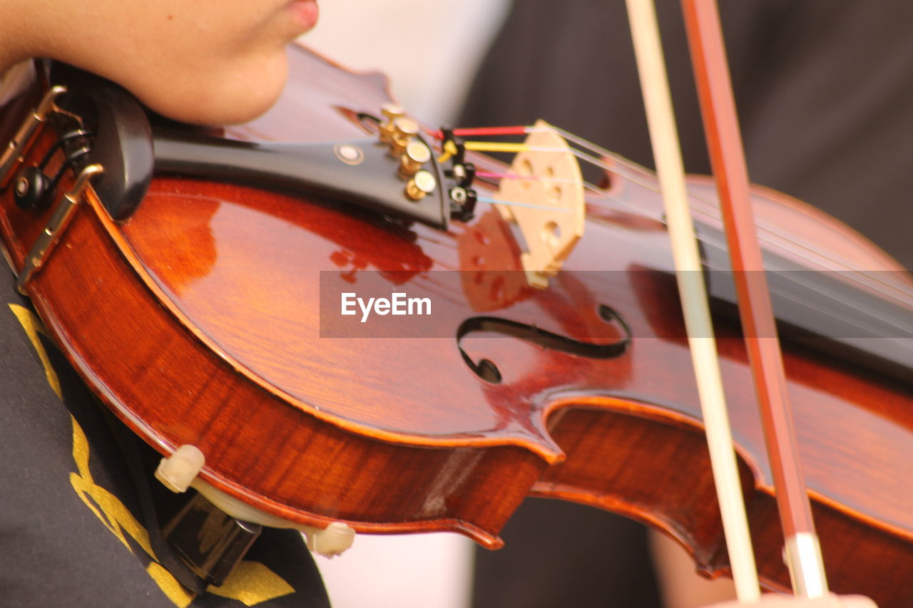Midsection of woman playing violin at event