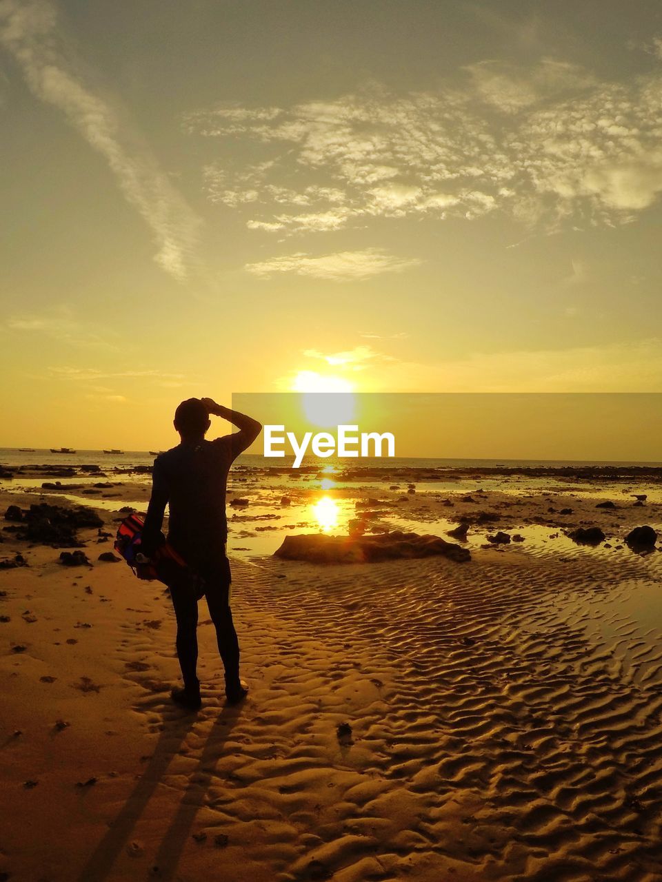SILHOUETTE BOY STANDING ON BEACH AGAINST SKY DURING SUNSET