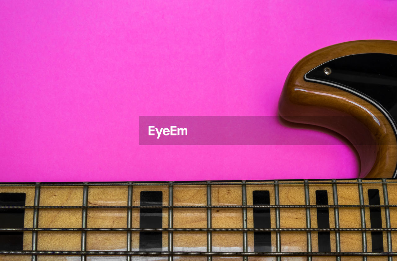 Close-up of electric guitar on pink table