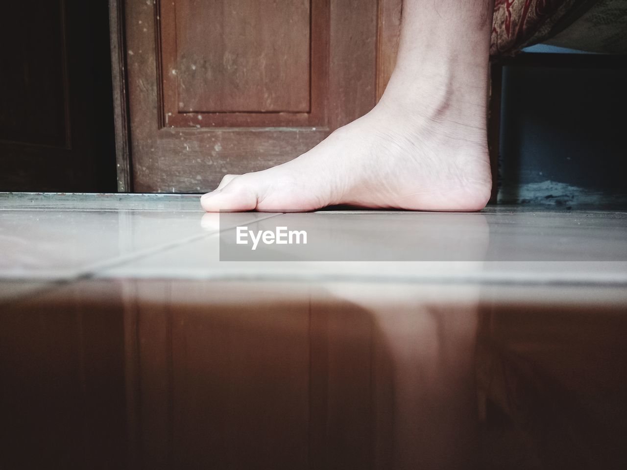 LOW SECTION OF PERSON WEARING WOODEN FLOOR