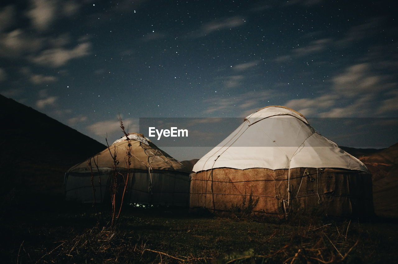 Tents on field against sky at night
