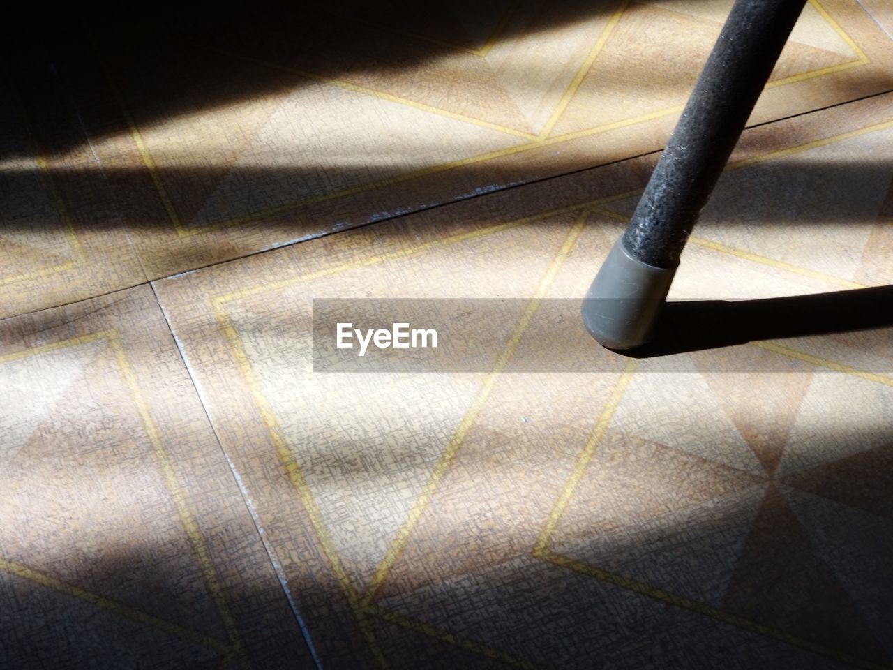 High angle view of metallic rod on tiled floor with shadow