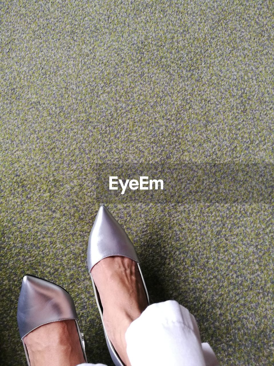 Low section of woman wearing shoes on floor