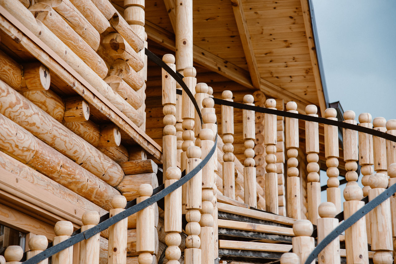 architecture, baluster, wood, built structure, stairs, no people, building exterior, building, wall, railing, outdoor structure, nature, day, handrail, beam, outdoors, staircase, industry, roof, low angle view, in a row, lumber, construction industry, pattern, house, sky