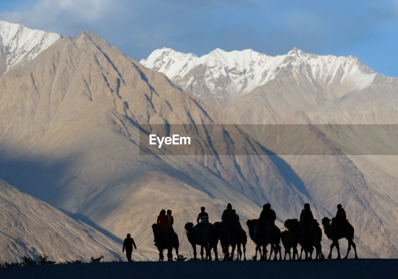 Group of people riding camel on mountain