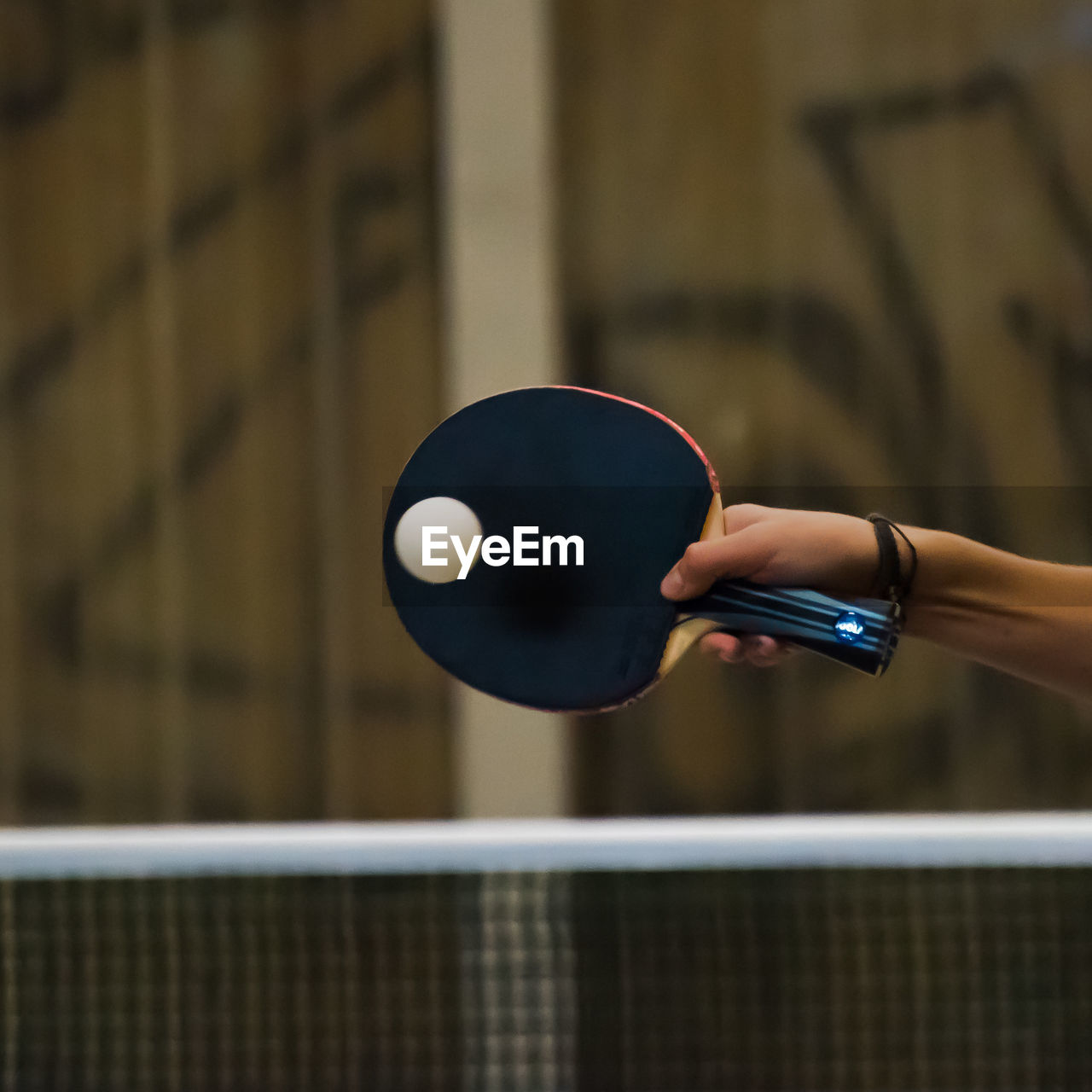 Cropped hand of woman playing table tennis