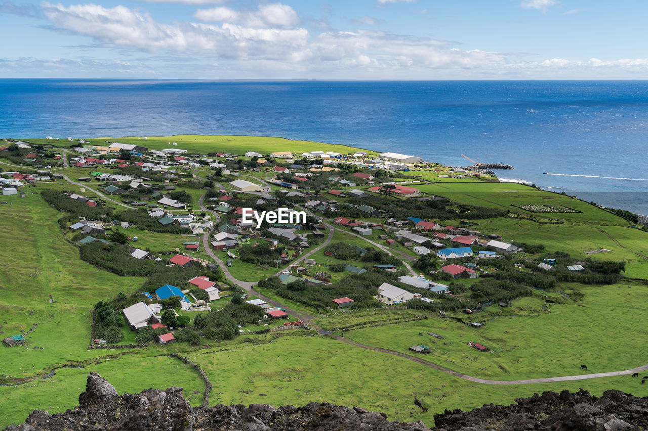 High angle view of village and sea against sky