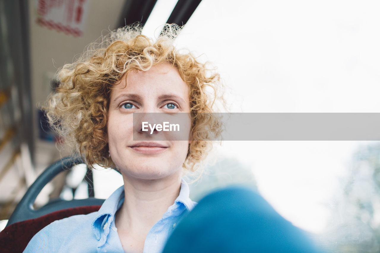 Portrait of smiling young woman in bus