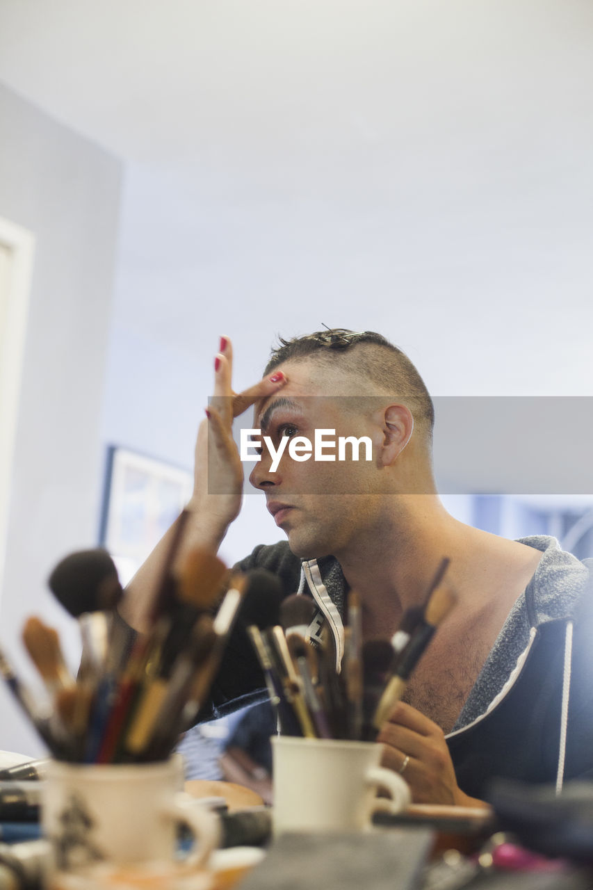 Man applying drag makeup