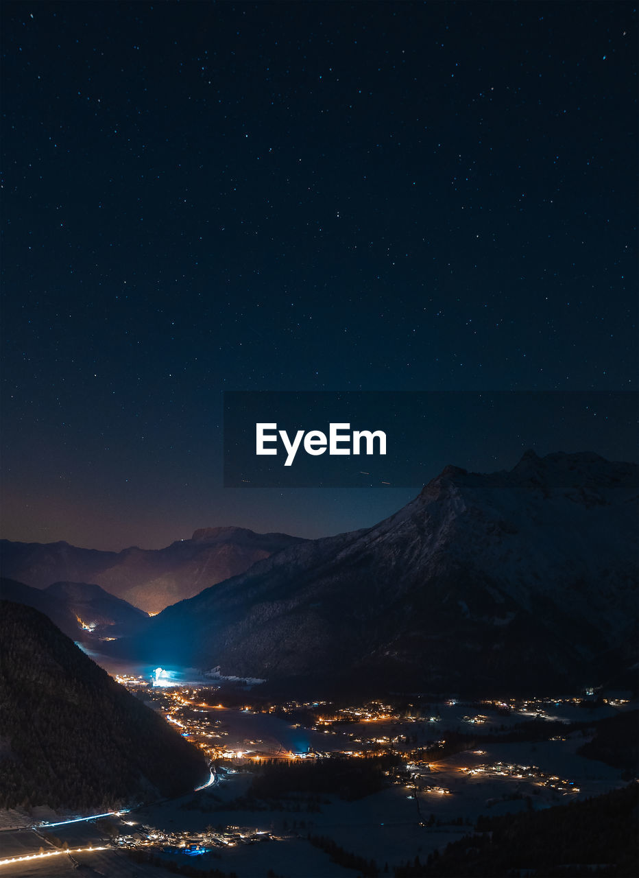 Scenic view of illuminated mountains against sky at night