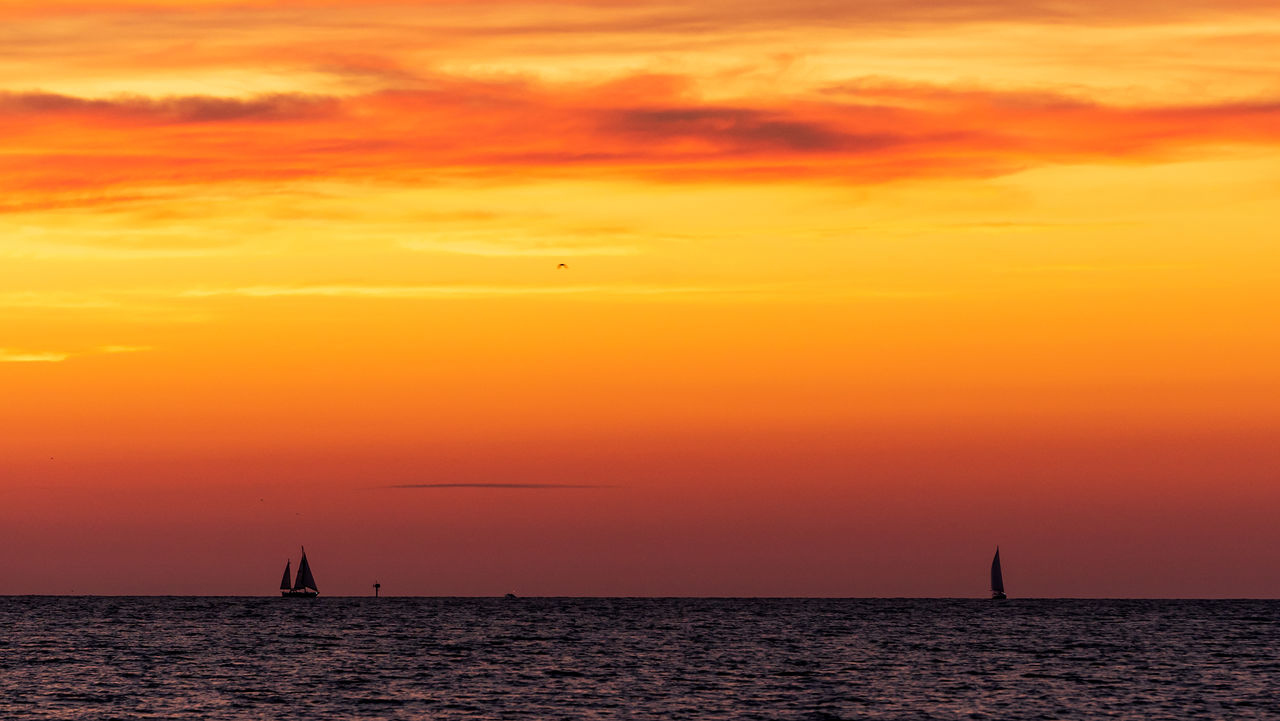 sea, sky, sunset, water, horizon, afterglow, beauty in nature, nautical vessel, cloud, orange color, transportation, nature, scenics - nature, horizon over water, silhouette, sailboat, dawn, sun, dramatic sky, tranquility, mode of transportation, sailing, environment, tranquil scene, travel, ocean, idyllic, outdoors, travel destinations, urban skyline, red sky at morning, no people, ship, sunlight, evening, seascape, architecture, sailing ship, vacation, holiday, romantic sky, trip, shore, moody sky, multi colored, landscape