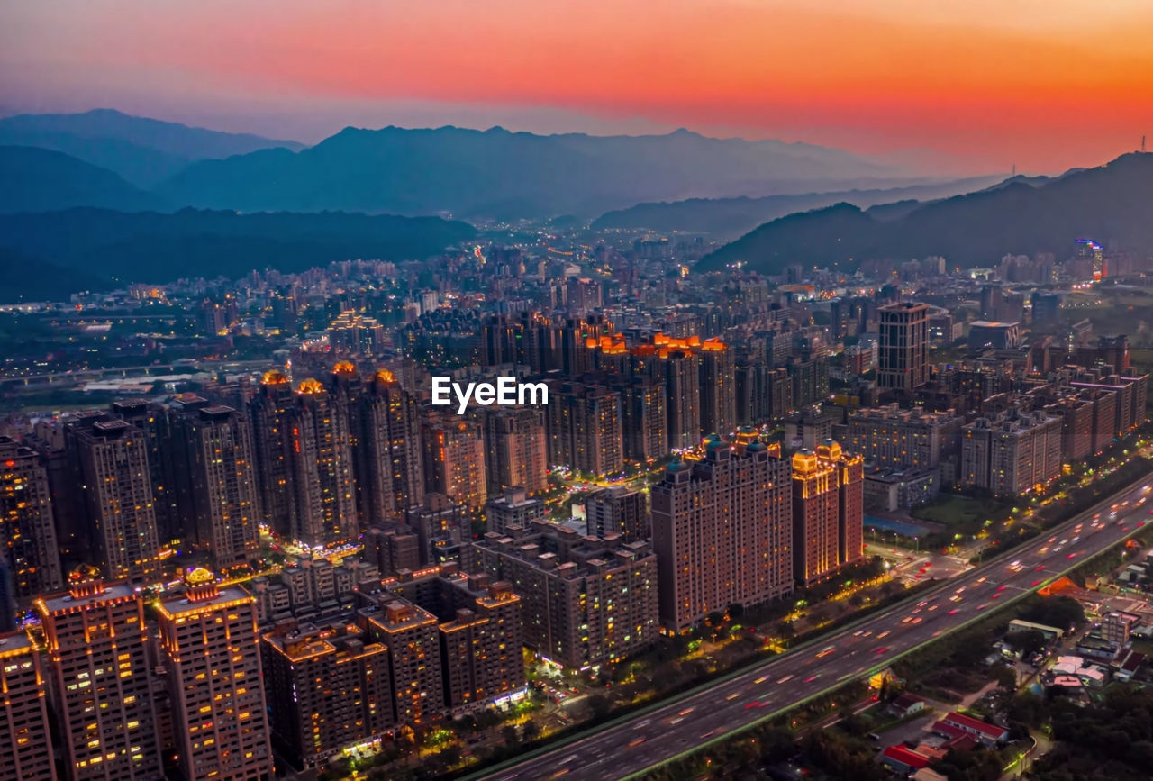 High angle view of city lit up at sunset