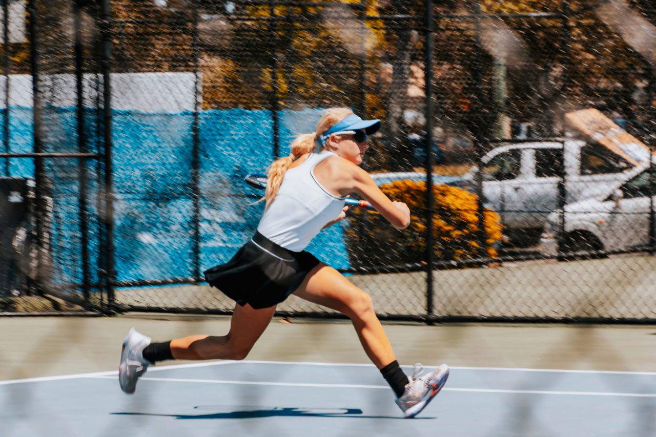Young female playing tennis, action shot
