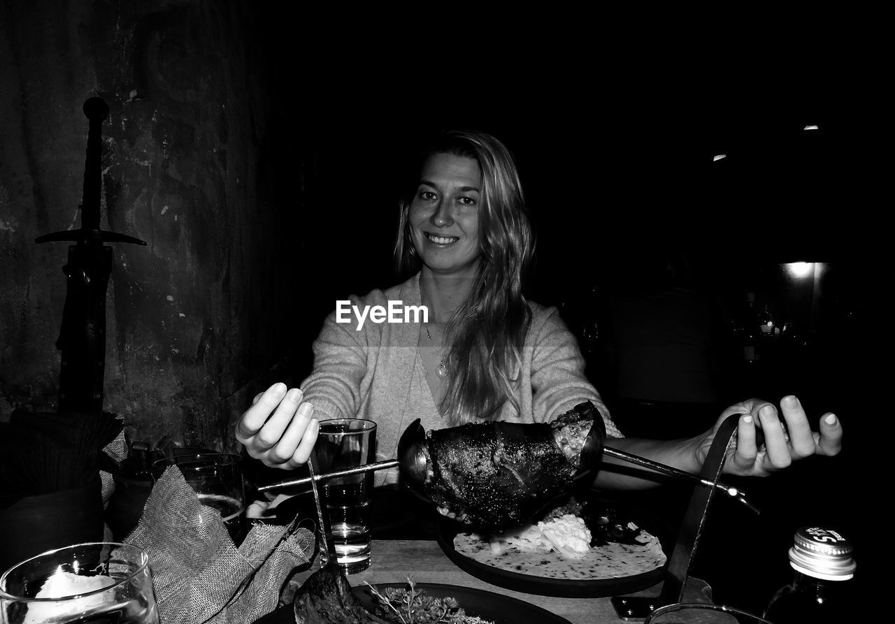 Woman about to eat a roast in a restaurant, in black and white