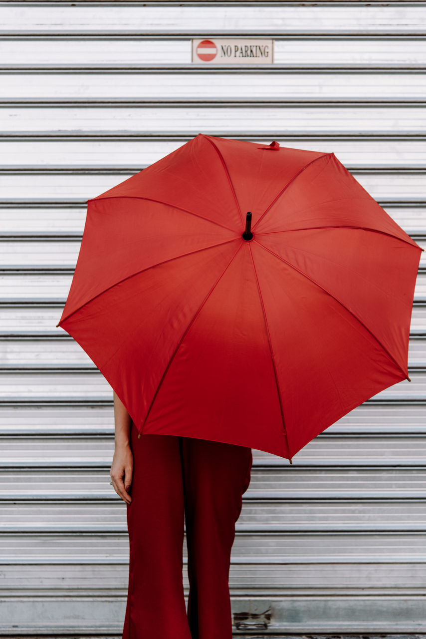 Low section of woman holding umbrella