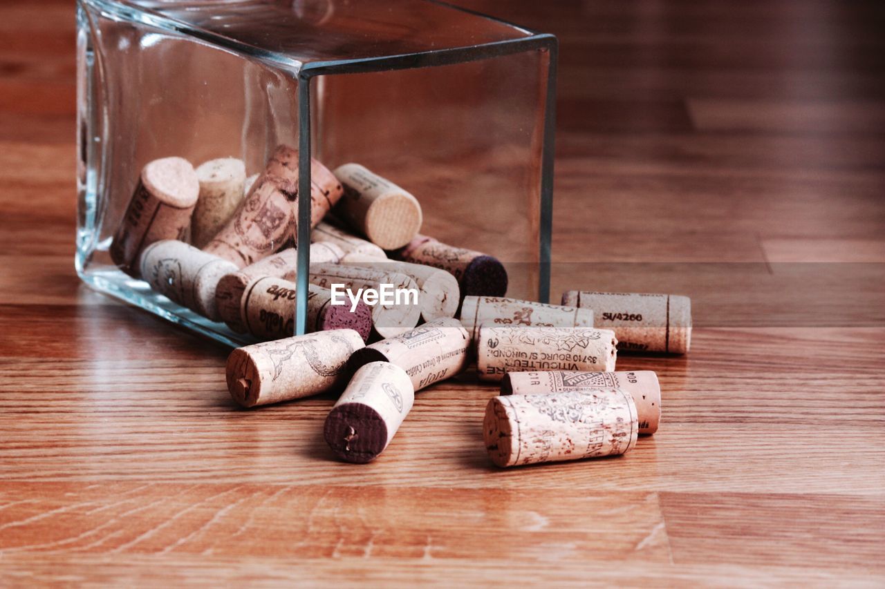 Wine corks in glass container on hardwood floor