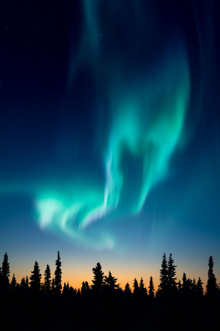 Low angle view of aurora borealis at sunset