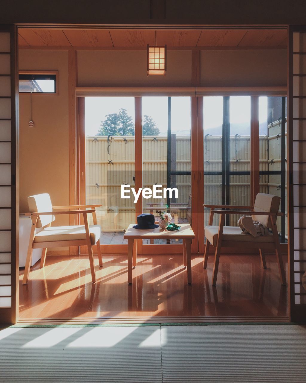 EMPTY CHAIRS AND TABLE BY WINDOW IN OFFICE