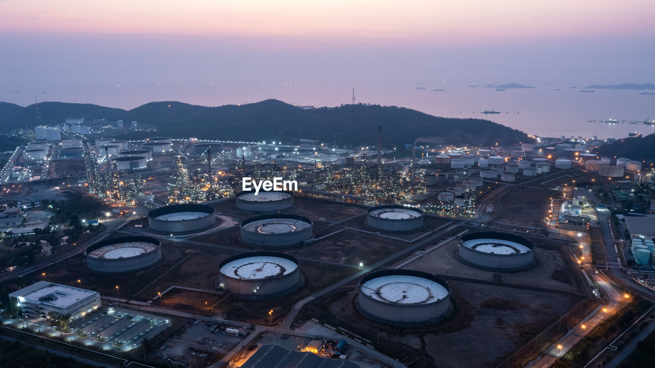 Aerial view industry factory oil and gas chemical tank and oil refinery and mountain at twilight
