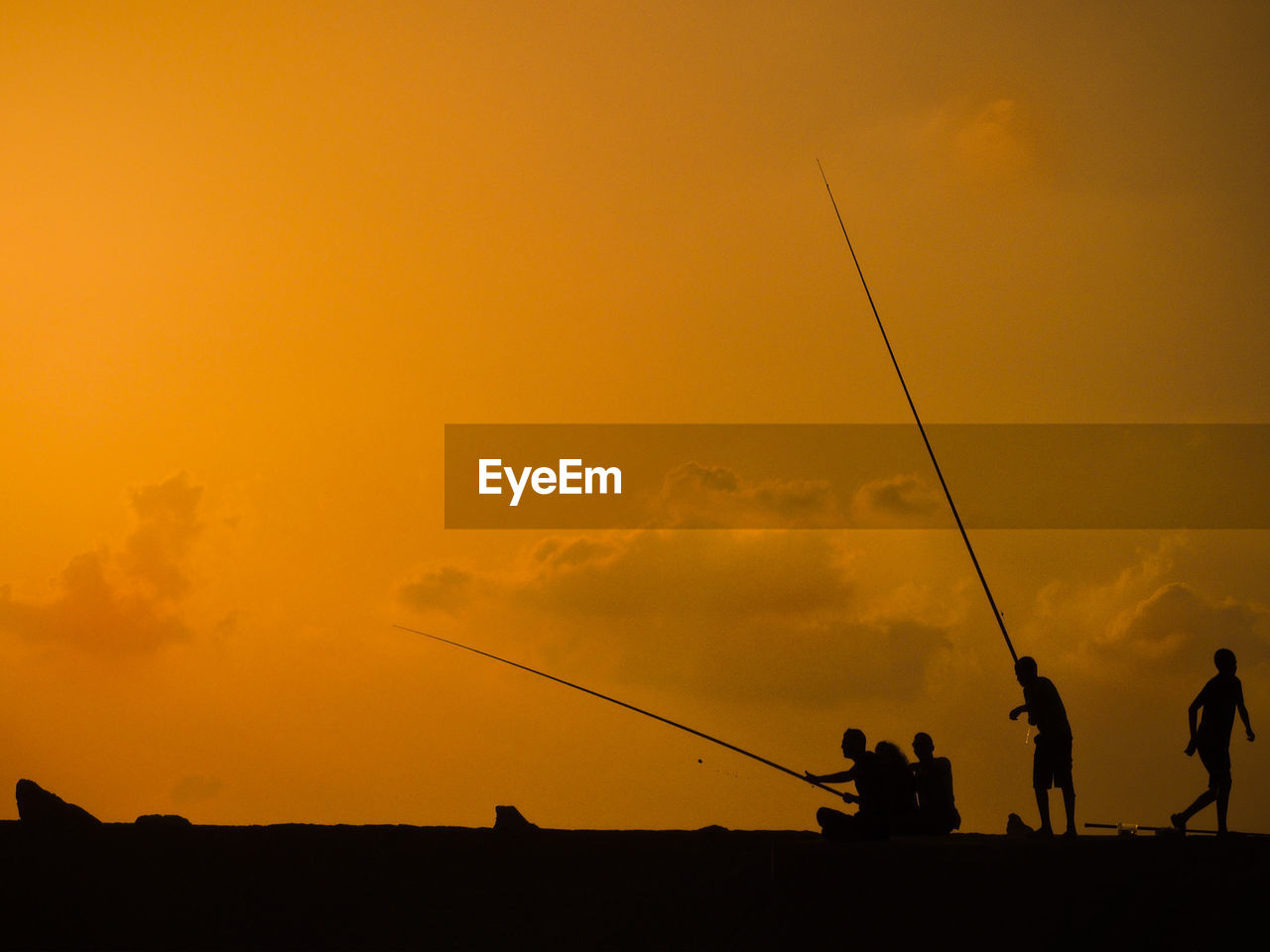 SILHOUETTE PEOPLE FISHING AT SUNSET