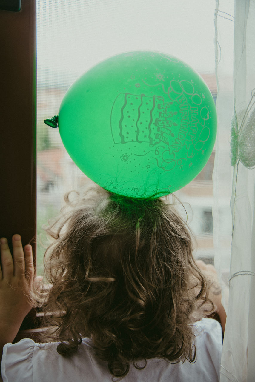 green, one person, child, childhood, rear view, women, headshot, indoors, balloon, hairstyle, portrait, female, adult, long hair, brown hair, lifestyles, blond hair, casual clothing, emotion, day, holding