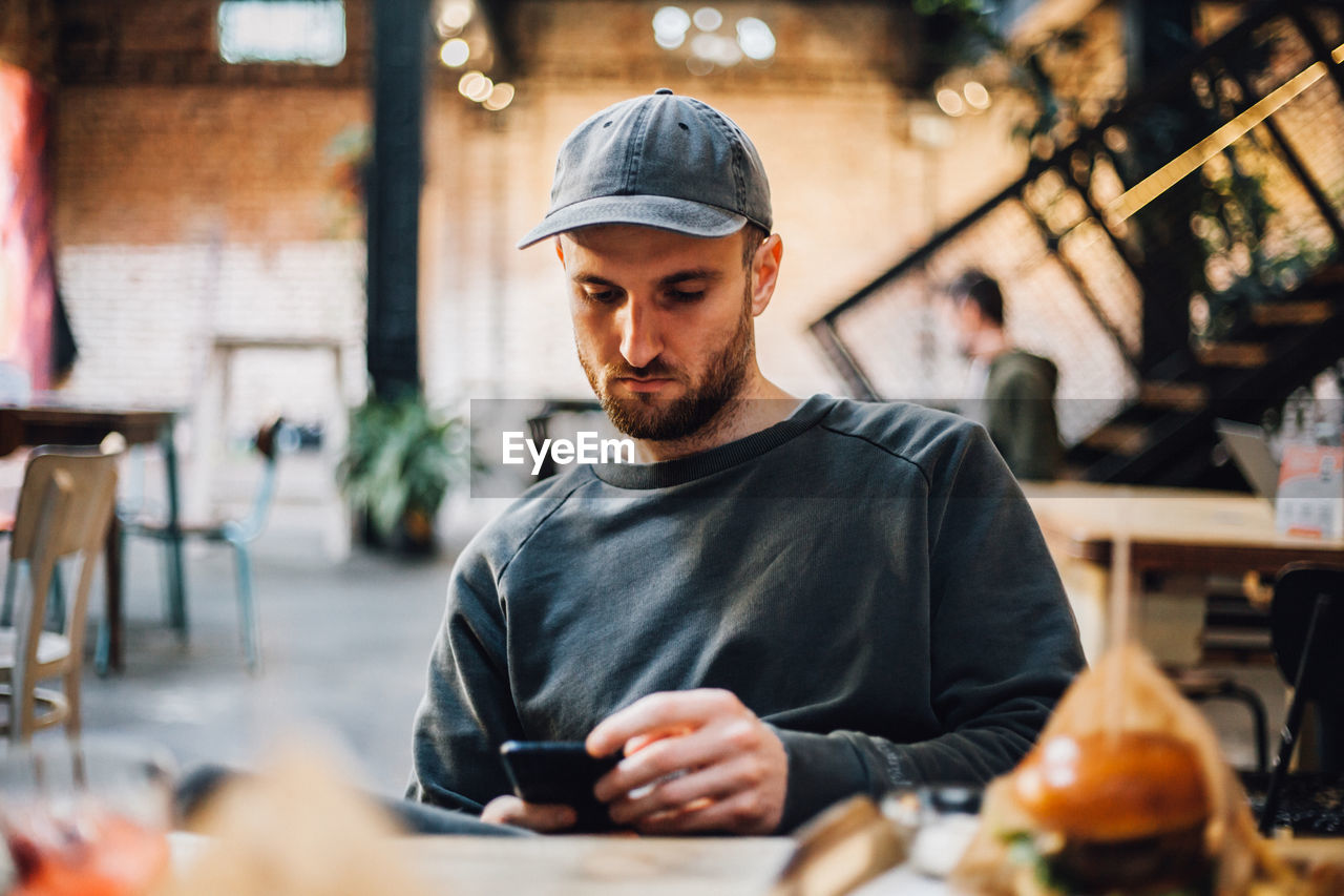 Man using mobile phone in cafe