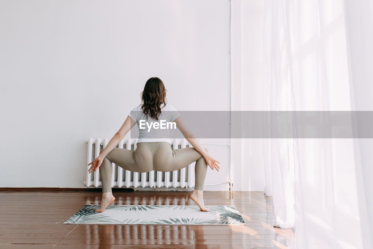 Athletic active young woman in sportswear doing a sports fitness workout in the morning at home