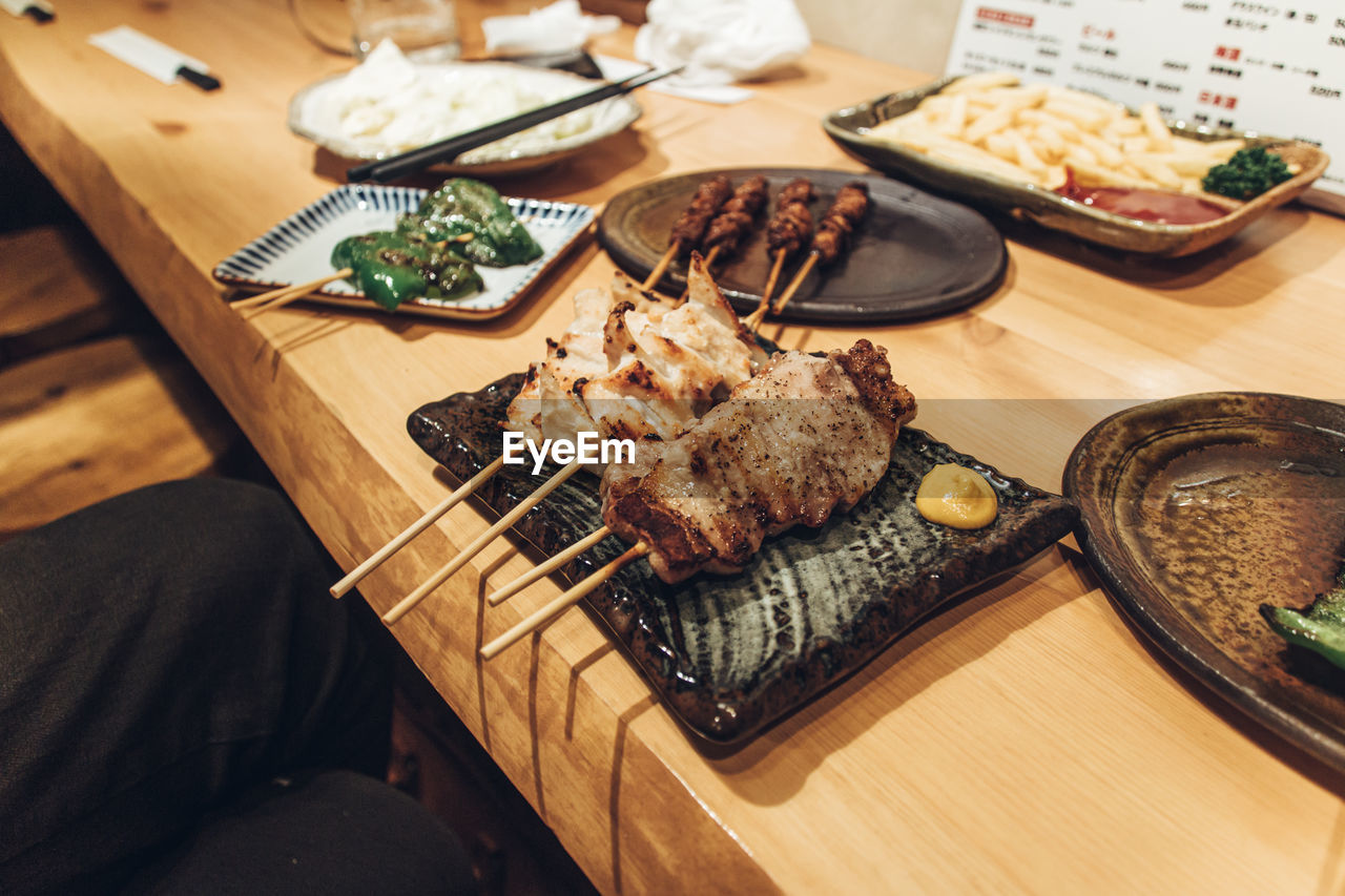 High angle view of yakitori and yakiton  served on table at izakaya restaurant in japan