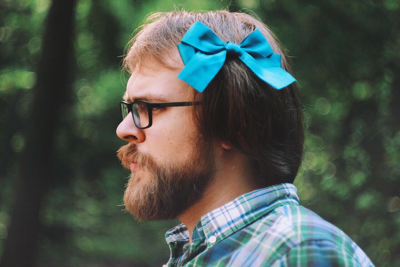 Side view of mid adult man wearing hair bow