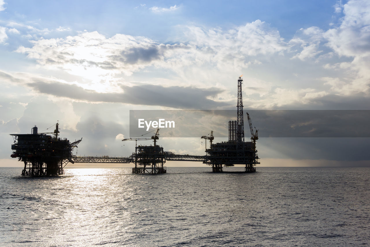 Silhouette of oil production platform complex during a cloudy evening at offshore oil field