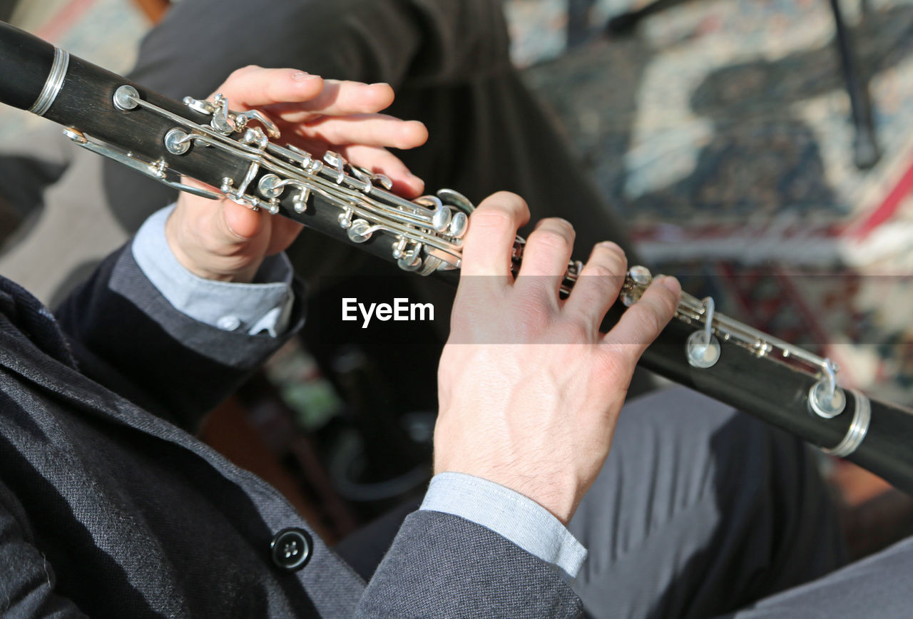 Midsection of man playing flute 