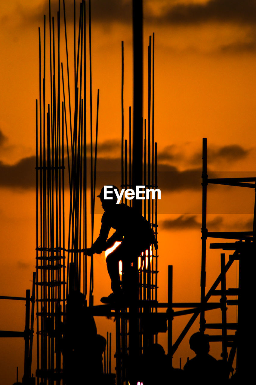 Silhouette of construction worker at sunset